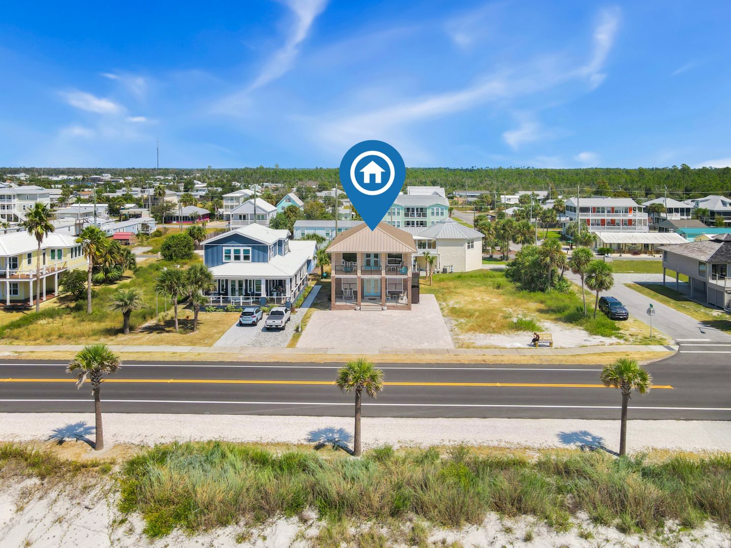 A coastal residential area with houses, a road, and a beach.