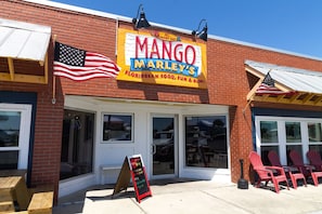 Ein Schaufenster mit einem Schild, auf dem 'Mango Marley's' steht, und einer amerikanischen Flagge.