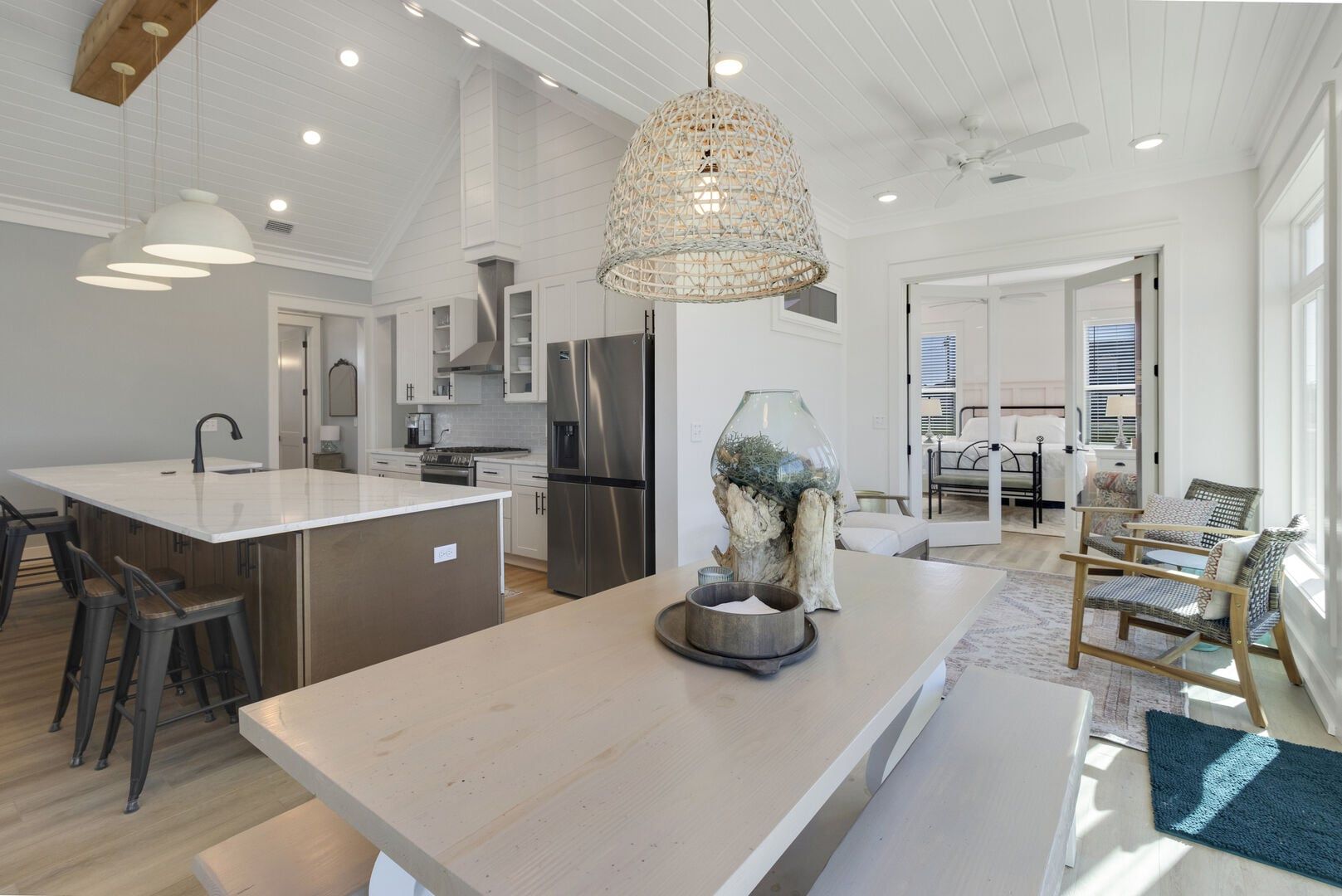 A modern kitchen with a central island, stainless steel appliances, and a hanging light fixture.