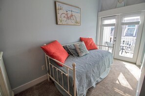 A bedroom with a bed, pillows, a painting, and a view through a door. - PEACEFUL EASY FEEELING OFFERS GULF VIEWS & STEPS FROM BEACH! COMMUNITY POOL! (Mexico Beach)
