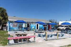 A beach-themed restaurant with outdoor seating and blue umbrellas. - PEACEFUL EASY FEEELING OFFERS GULF VIEWS & STEPS FROM BEACH! COMMUNITY POOL! (Mexico Beach)