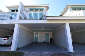 A two-story residential building with a covered garage and a balcony. - PEACEFUL EASY FEEELING OFFERS GULF VIEWS & STEPS FROM BEACH! COMMUNITY POOL! (Mexico Beach)