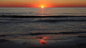 A sunset over a calm sea with waves gently lapping at the shore. - PETE'S PARADISE IS MODERN, SPACIOUS FLOOR PLAN! GREAT FENCED IN BACKYARD WITH FI (Port Saint Joe)