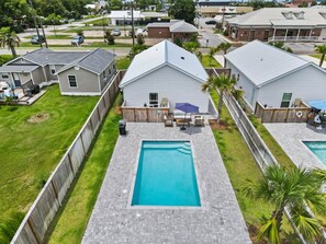 A residential area with a swimming pool, fenced yard, and houses with attached garages. - Salty Blue is a new 2BD/2BA cottage, walking distance to restaurants & shops! Po (Port Saint Joe)