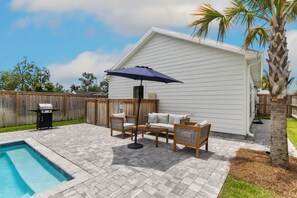 A backyard with a pool, patio furniture, and a covered seating area. - Salty Blue is a new 2BD/2BA cottage, walking distance to restaurants & shops! Po (Port Saint Joe)