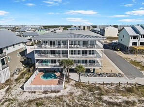 A multi-story residential building with a swimming pool and a fenced patio area. - "Sandals and Sunsets" located in a gulf front community! Steps to paradise! Pet (Mexico Beach)