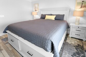 Ein Schlafzimmer mit einem großen Bett, Nachttischen und einem Kopfteil.
