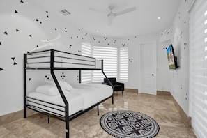 A bunk bed with a TV mounted on the wall, a patterned rug, and a ceiling fan. - Luxury Mansion | 5K SF | Pool & Game Room (Hollywood)