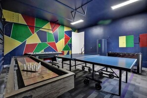 A room with a ping pong table, a foosball table, and a billiards table. - Luxury Mansion | 5K SF | Pool & Game Room (Hollywood)