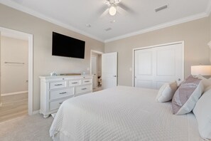 A bedroom with a large bed, a dresser, a television mounted on the wall, and a door leading to another room. - NEW LISTING!! Saltwater & Sunsets at Lost Key Golf & Beach Club (Perdido Key)