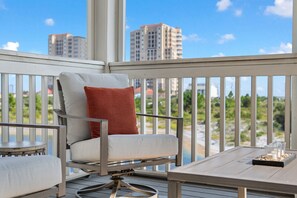 A balcony with a chair and table, overlooking a cityscape. - NEW LISTING!! Saltwater & Sunsets at Lost Key Golf & Beach Club (Perdido Key)