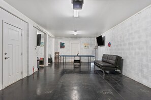 A spacious room with a black leather couch, a table, and a television mounted on the wall. - NEW LISTING!! Saltwater & Sunsets at Lost Key Golf & Beach Club (Perdido Key)