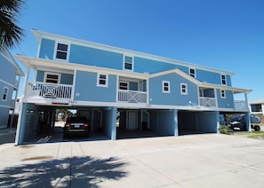 A multi-story residential building with a blue exterior, numbered 3201, featuring a covered parking area with a car and a construction vehicle. - SHORE BEATS WORK IS 500 STEPS TO BEACH! MODERN, IMMACULATE TOWNHOME! (Mexico Beach)