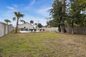 A backyard with a pool, lounge chairs, and a wooden fence. - Simple Pleasures, 2BD cottage, walk to restaurants, shops, St. Joe Bay! Private (Port St. Joe)