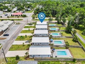 Un quartier résidentiel comprenant plusieurs maisons, un complexe de piscines et une route.
