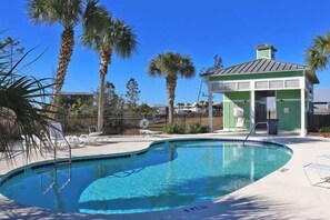 A swimming pool with lounge chairs and a small pavilion. - Stella Maris, 3BD/2BA modern home, option to rent golf cart, community pool, pet (Mexico Beach)