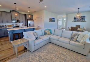 A modern kitchen with a built-in microwave, refrigerator, and a bar area. - Stella Maris, 3BD/2BA modern home, option to rent golf cart, community pool, pet (Mexico Beach)