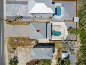 Una propiedad residencial con piscina, patio cubierto y techo en forma de estrella.