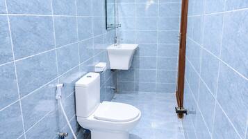 Un baño con inodoro, bidé y ducha.