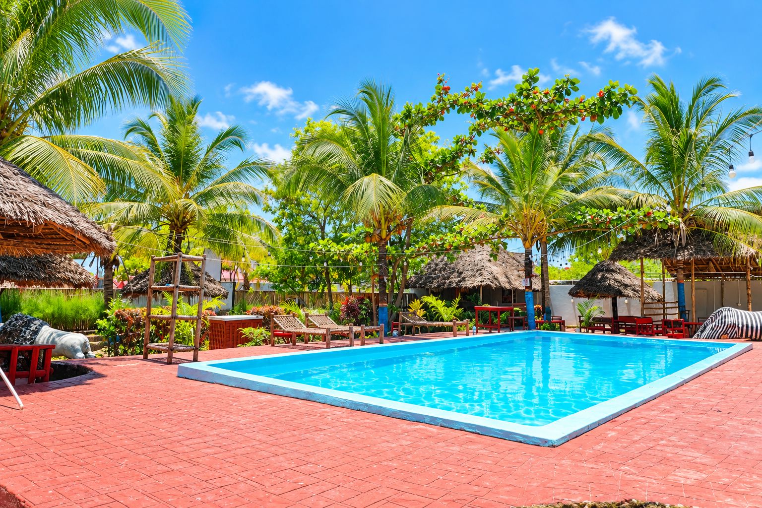 A swimming pool with lounge chairs and palm trees.