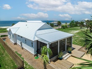 A coastal house with a large glass window, a metal roof, and a wooden deck. - The Dune Buggie is an elegant, custom built 3BD/3BA home w/gulf views from every (Port Saint Joe)
