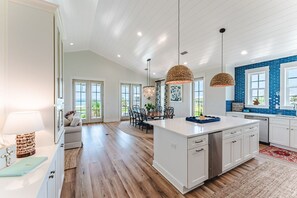 A spacious kitchen with a central island, wooden flooring, and pendant lighting. - The Dune Buggie is an elegant, custom built 3BD/3BA home w/gulf views from every (Port Saint Joe)