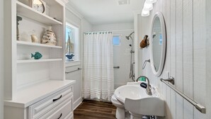A bathroom with a white vanity, a sink, a shower, and a mirror. - "Water of Life" offers panoramic views, steps to the beach, screened-in porch, p (Port Saint Joe)