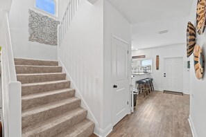 Eine Treppe führt zu einer Küchenzeile mit einer Bar und Hockern.