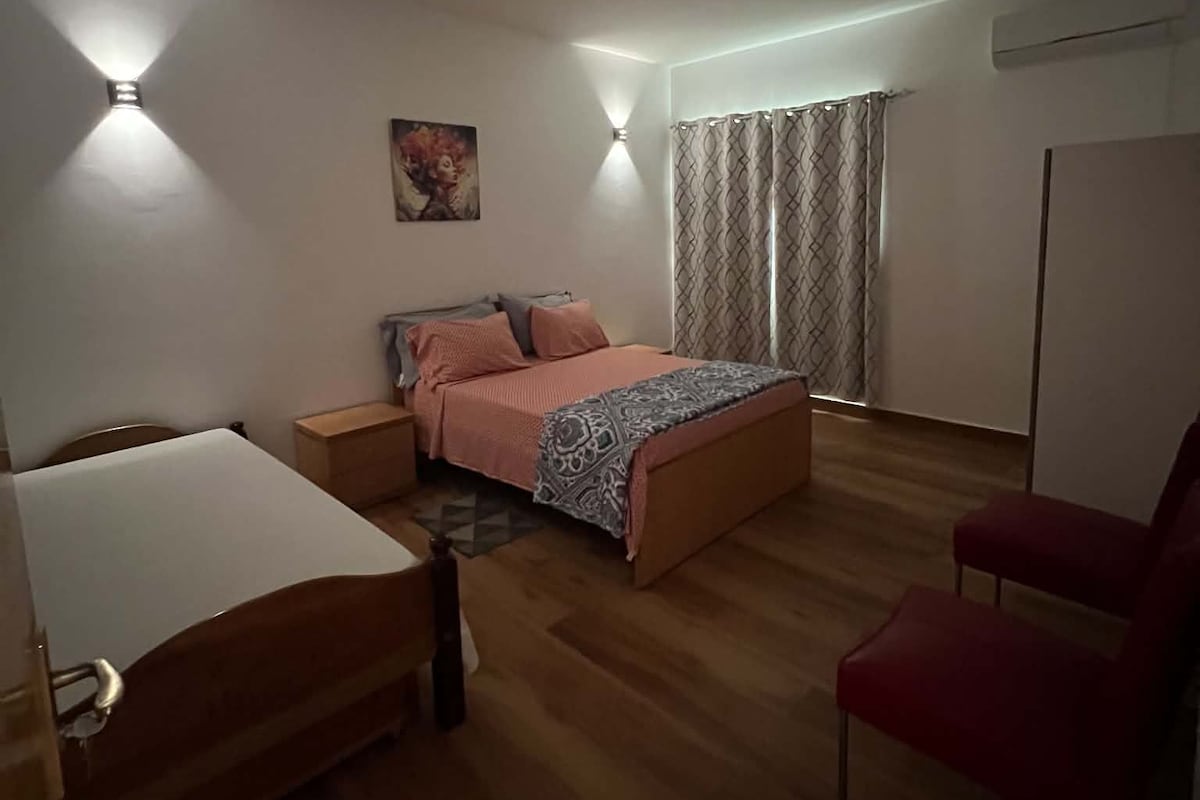 Un dormitorio con cama, escritorio, silla y armario.