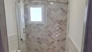 A bathroom with a shower, toilet, and a small window. - Holiday Home 'Relaxing Cozy House' with Mountain View, Shared Pool and Wi-Fi (Santa Pola)