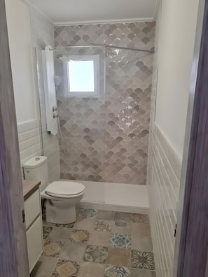 A bathroom with a shower, toilet, and a small window. - Holiday Home 'Relaxing Cozy House' with Mountain View, Shared Pool and Wi-Fi (Santa Pola)