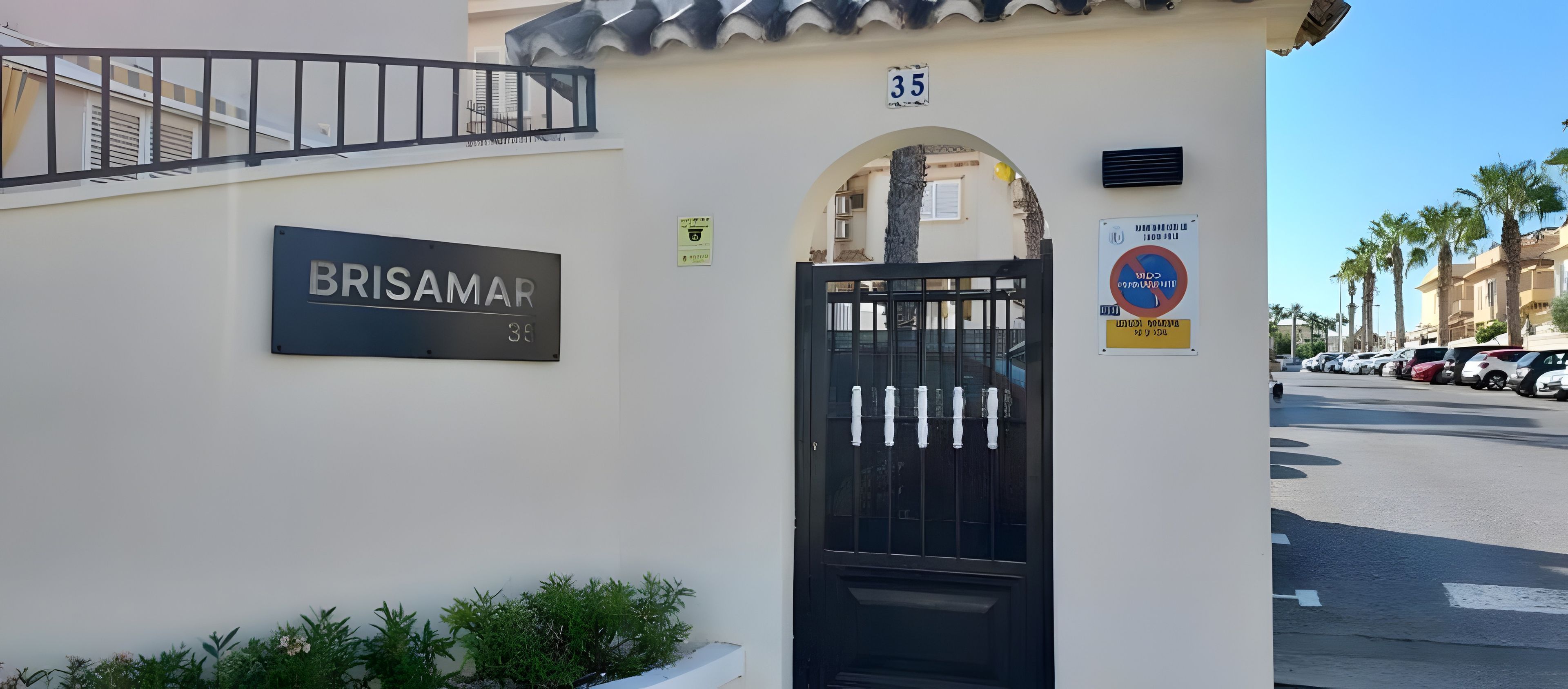 Un bâtiment avec une enseigne indiquant « BRISAMAR 35 » et un portail noir.
