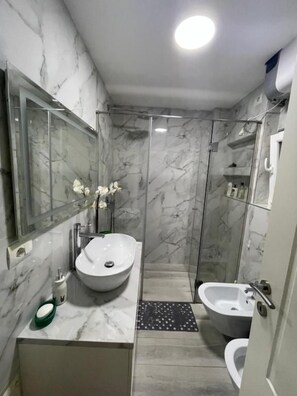A bathroom with a marble sink, a glass shower enclosure, and a toilet. - Modern Cozy Apartment, Close to Pazari i Ri, Tirana Self Check-in Free Wifi (Tirana)
