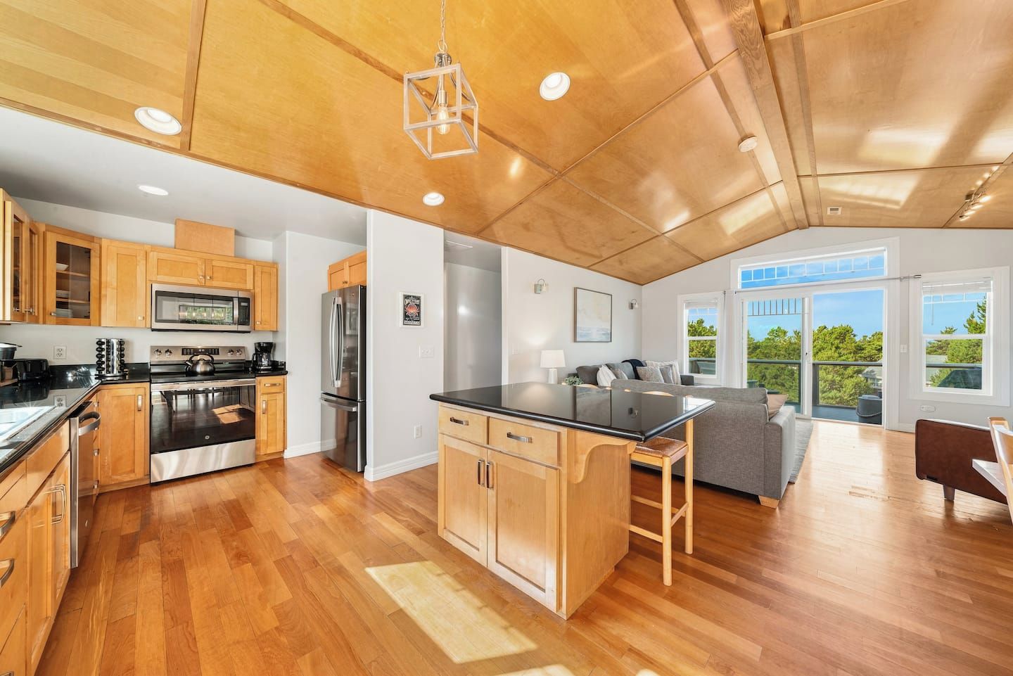 A modern kitchen with wooden cabinets, stainless steel appliances, and a central island.