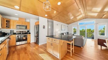 A modern kitchen with wooden cabinets, stainless steel appliances, and a central island.