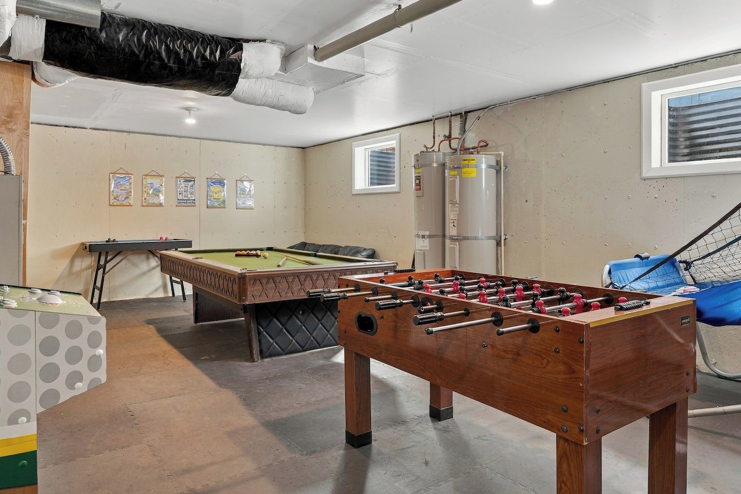 Una sala de recreación con mesa de fútbol, mesa de billar y mesa de carambola.