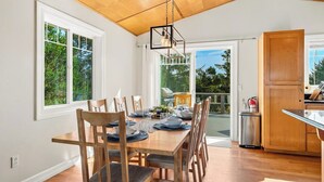 Comedor con mesa de madera dispuesta para seis personas, rodeada de sillas con asientos acolchados.