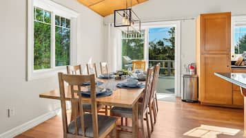 Comedor con mesa de madera dispuesta para seis personas, rodeada de sillas con asientos acolchados.