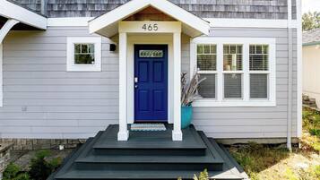 A house with a blue front door, a number '465' above it, and a small porch with steps leading up to the door.