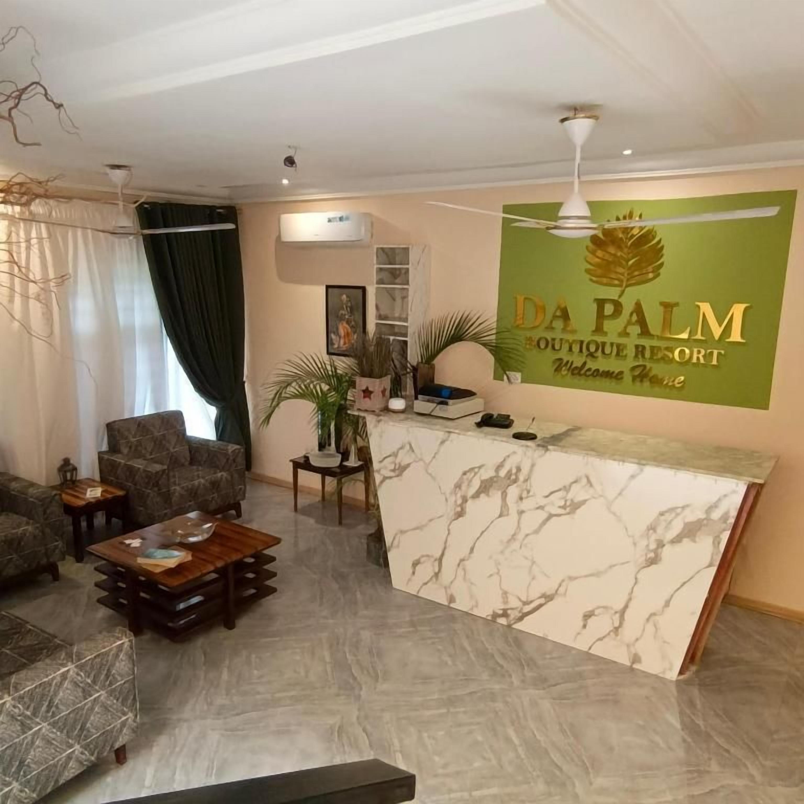 Uma área de recepção com balcão de mármore, ventilador de teto e placa na parede para Da Palm Boutique Resort.