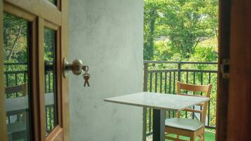 A room with a door, a small table, and a chair.