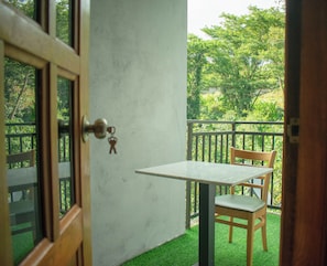 A room with a door, a small table, and a chair.