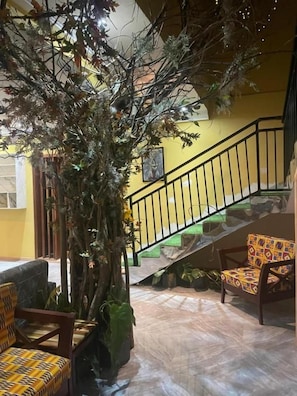 A staircase with a black railing, a wooden bench, and a potted plant.