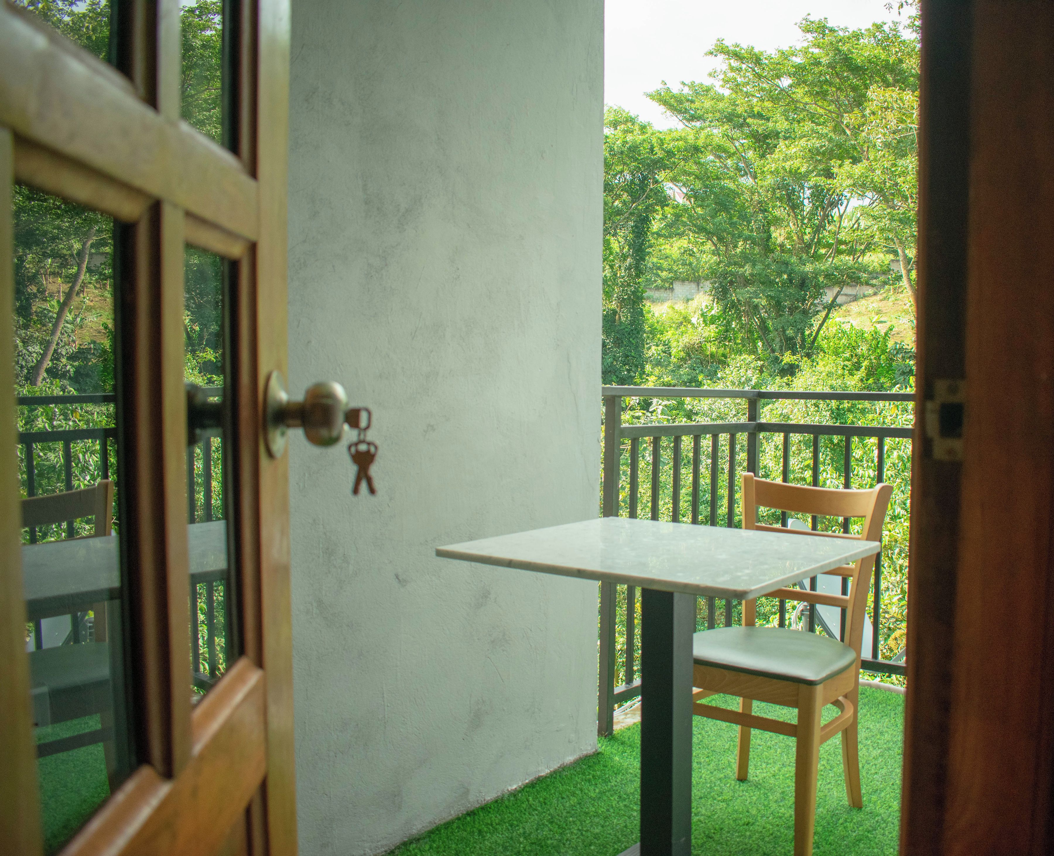Una habitación con una puerta, una mesita y una silla.