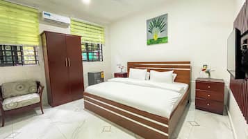 Un dormitorio con cama, armario, mesita de noche, espejo y ventana con persianas.