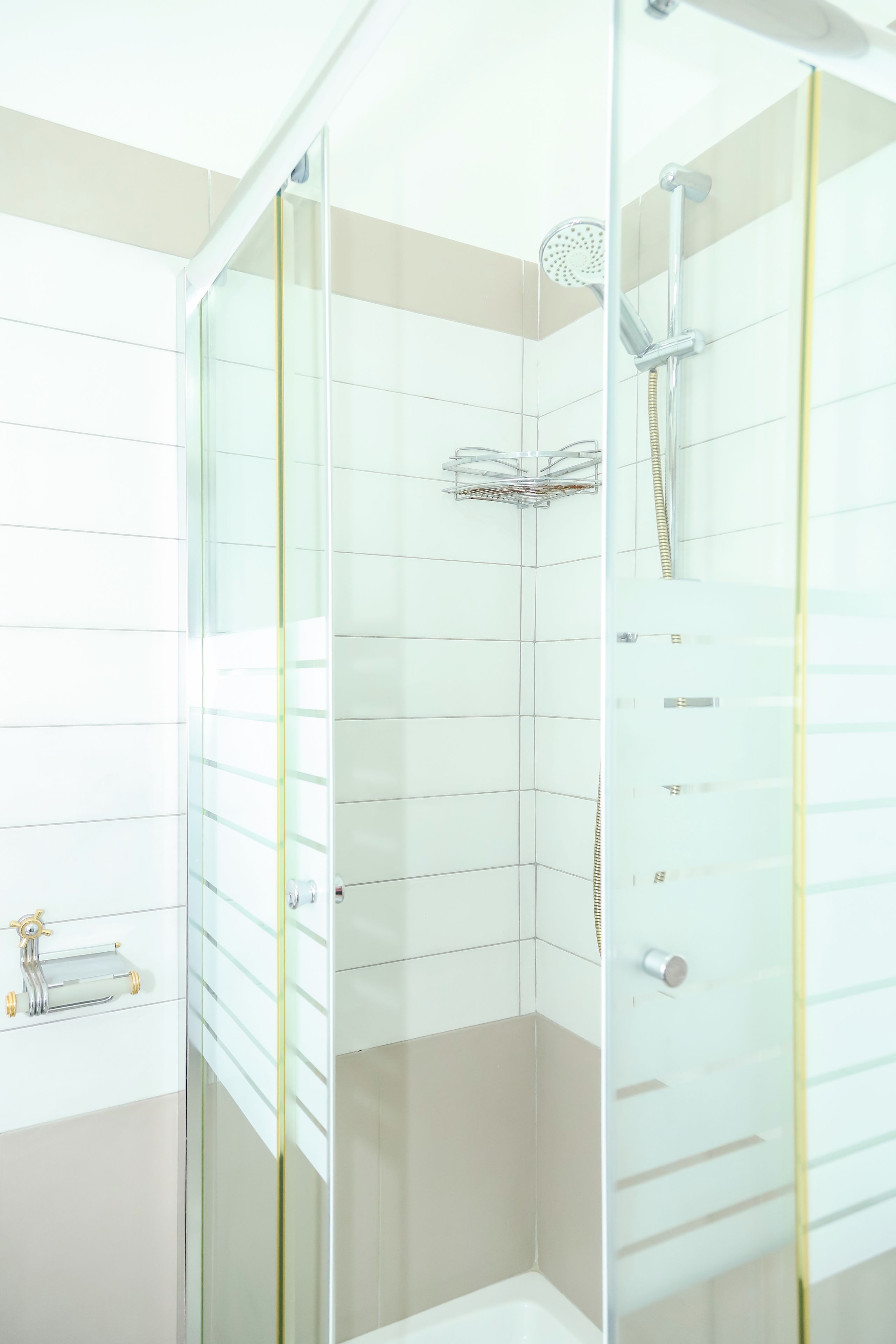 Une salle de bain moderne dotée d’une douche à parois de verre, de toilettes et d’un lavabo avec un porte-serviettes.