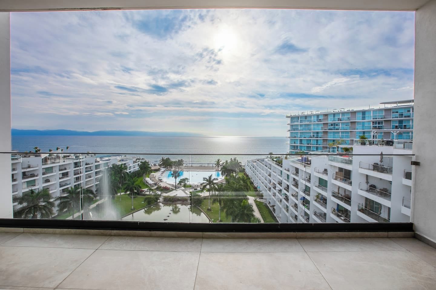 Un hôtel de grande hauteur offrant une vue sur la mer et doté d’un espace piscine.