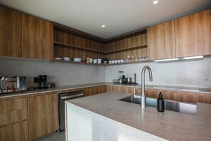 A modern kitchen with wooden cabinets, a stainless steel sink, and a built-in dishwasher. - Aria 3BR Private Jacuzzi & Terrace Nuevo Vallarta (Nuevo Vallarta)