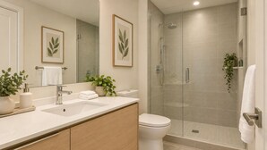 Ein modernes Badezimmer mit Duschkabine aus Glas, einem weißen Waschbecken und einer Toilette.