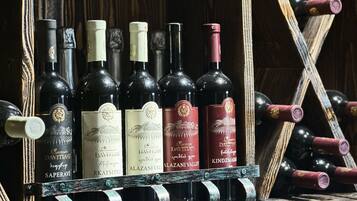 A rack of wine bottles with labels, some with corks, in a wooden setting.